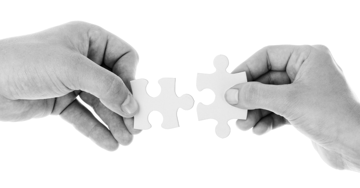 Hands putting two puzzle pieces together illustrating how ISVs help enhance and expand Acumatica ERP capabilities.